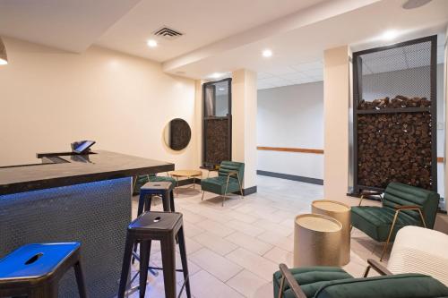 a waiting room with green chairs and a table at Holiday Inn & Suites Goodyear - West Phoenix Area by IHG in Goodyear