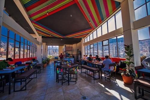 people sitting at tables in a restaurant with a colorful ceiling at ISKAY BOUTIQUE HOSTEL in La Paz