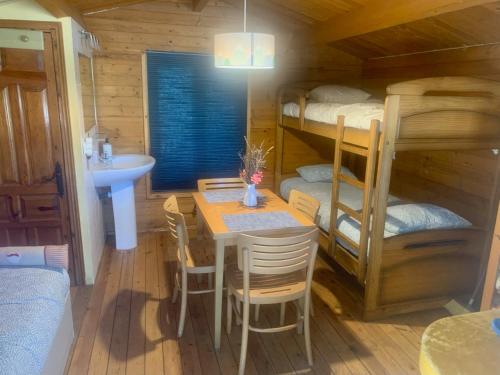 a dining room with a table and bunk beds at La Cabaña de Gaia in San Lorenzo de El Escorial