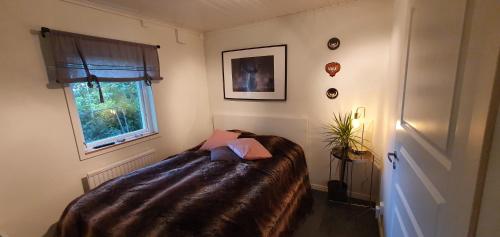 1 dormitorio con cama y ventana en Gästhus i lugnt område. 3km från Örebro slott en Örebro