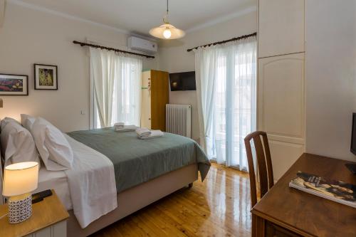 a bedroom with a bed and a table with a desk at Pausa Verde in Corfu city in Corfu Town