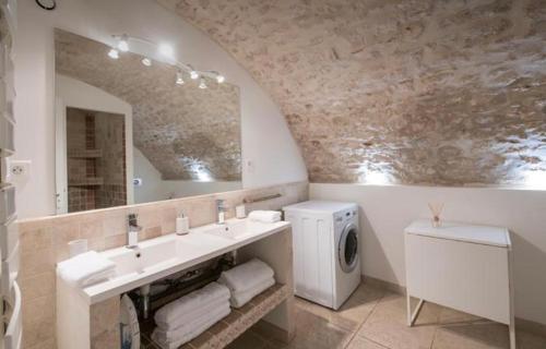 a bathroom with a sink and a mirror and a washing machine at LE BON'APPART proche INSEAD in Fontainebleau
