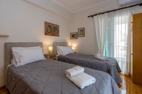 a bedroom with two beds and a window at Pausa Verde in Corfu city in Corfu Town