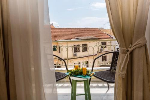 a balcony with a table and chairs and a building at Pausa Verde in Corfu city in Corfu Town