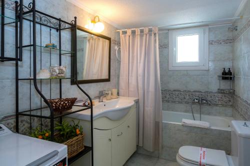 a bathroom with a sink and a toilet and a mirror at Pausa Verde in Corfu city in Corfu Town