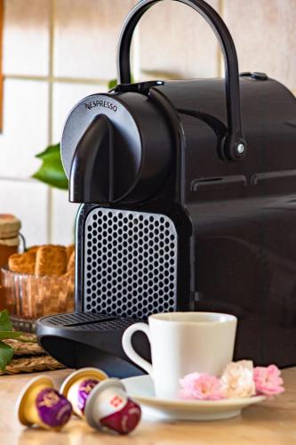 a coffee maker with a cup and a plate of donuts at Pelagia Apartments in Koroni