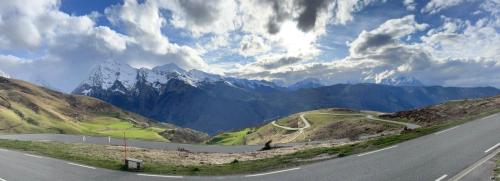 an empty road in the mountains under a cloudy sky at Piste verte à Peyragudes T2 4-6P, proche Loudenvielle in Loudenvielle
