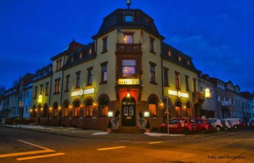 a large building on the side of a street at night at Stay2Night Hotel in Dillingen an der Saar