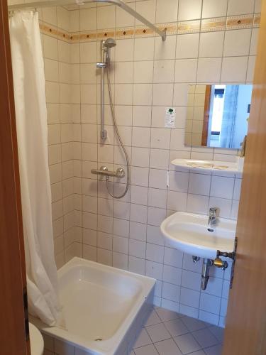 a bathroom with a tub and a sink and a shower at Stay2Night Hotel in Dillingen an der Saar