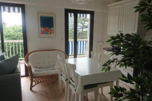 een eetkamer met een witte tafel en stoelen bij Spacious 70 m flat with Balcony and sea view! in Cannes