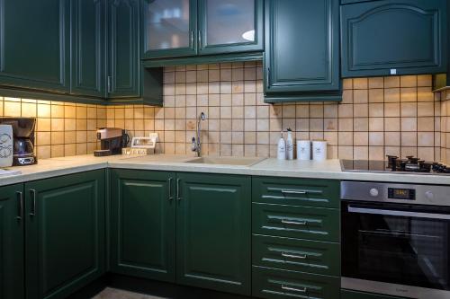 a green kitchen with green cabinets and a sink at Pausa Verde in Corfu city in Corfu Town
