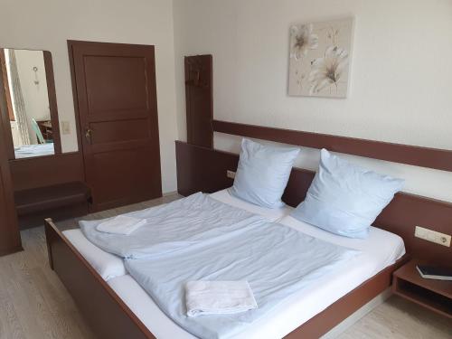 a bed with white sheets and pillows in a room at Stay2Night Hotel in Dillingen an der Saar