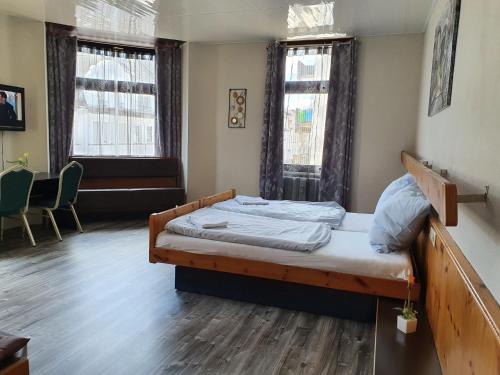 a bedroom with a bed and two windows at Stay2Night Hotel in Dillingen an der Saar