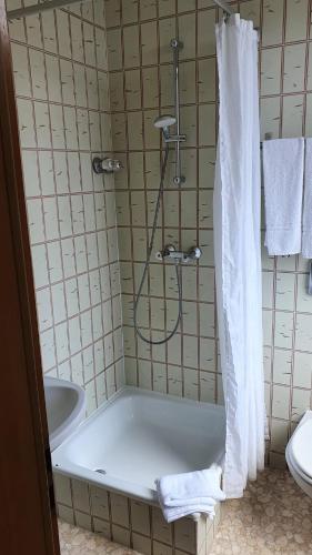 a bathroom with a shower with a tub and a sink at Stay2Night Hotel in Dillingen an der Saar