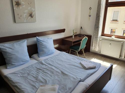 a bedroom with a bed with a desk and a chair at Stay2Night Hotel in Dillingen an der Saar