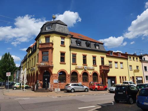a yellow building with cars parked in front of it at Stay2Night Hotel in Dillingen an der Saar
