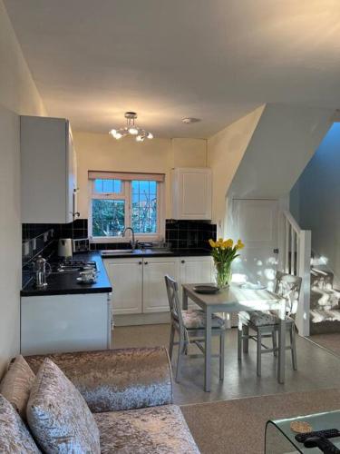 a kitchen and dining room with a table and chairs at Self contained, spacious annex with private drive. in Kent