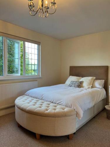 a bedroom with a large white bed with a large window at Self contained, spacious annex with private drive. in Kent