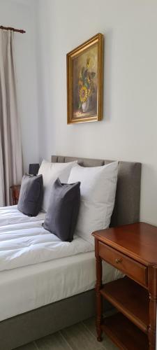 a bed with pillows and a picture on the wall at SUKIENNICE MIĘDZYLESIE in Międzylesie