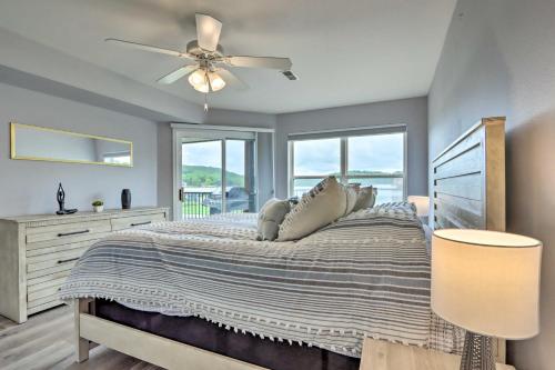 a bedroom with a bed with a ceiling fan and windows at Camdenton Condo with Pool Access and Lake Views! in Camdenton