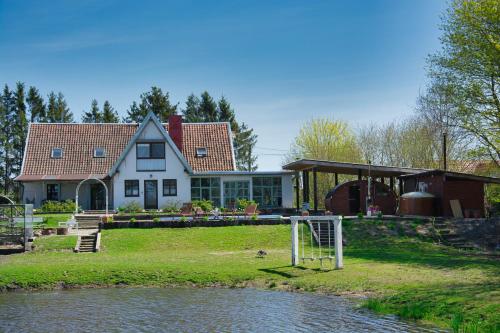 une maison à côté d'une rivière avec une maison dans l'établissement Chata Pogaduchy, à Ronin