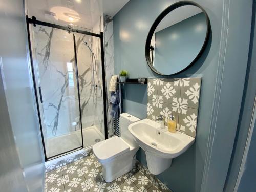 een badkamer met een toilet, een wastafel en een spiegel bij Westbay Seafront Apartment in Oban