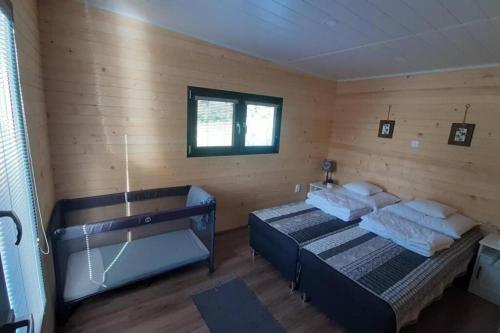 a bedroom with two beds in a room with wooden walls at Dom na jazere in Pliešovce