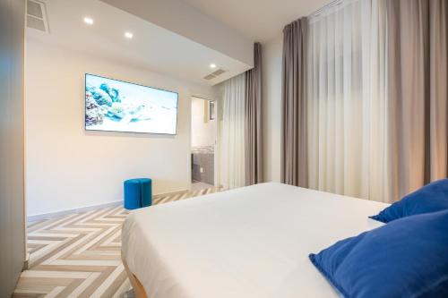 a bedroom with a bed and a tv on the wall at Garden Suite in Marina di Pietrasanta