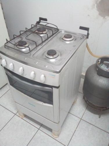 a stove in a kitchen with a pot next to it at Casa Central Ribeirao in Ribeirão Preto