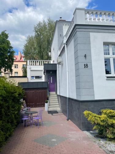 a house with a table and chairs in front of it at Willa 1936 , Parking in Toruń