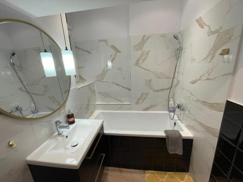 a bathroom with a sink and a tub and a mirror at Willa 1936 , Parking in Toruń