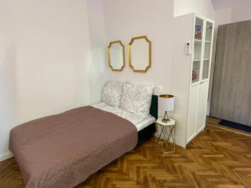 a bedroom with a bed and two mirrors on the wall at Willa 1936 , Parking in Toruń
