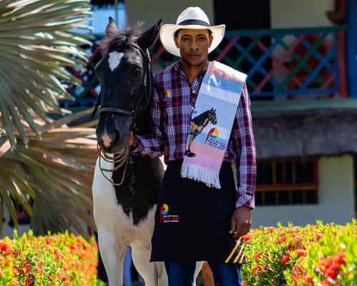 a man in a cowboy hat standing next to a horse at Hotel Agroturistico Palma Vino in Arboletes