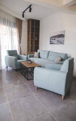 a living room with two blue couches and a table at Allure Apartments in Ulcinj