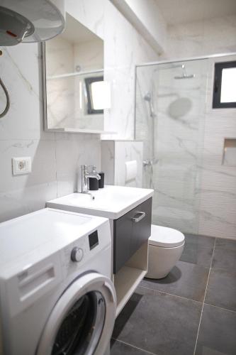 a bathroom with a washing machine and a toilet at Allure Apartments in Ulcinj