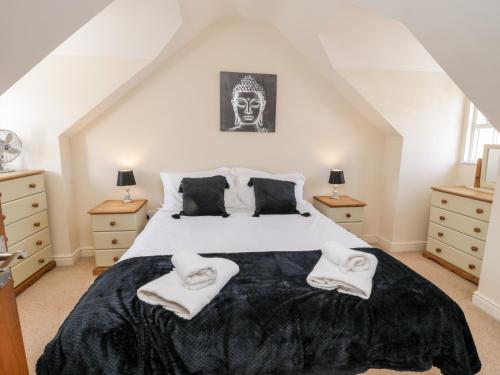 a bedroom with a large bed with two towels on it at Razorbill Cottage in Whitby