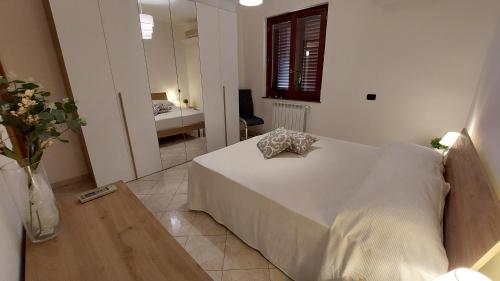 a bedroom with a white bed and a room with a desk at A me Casa in Gioiosa Marea