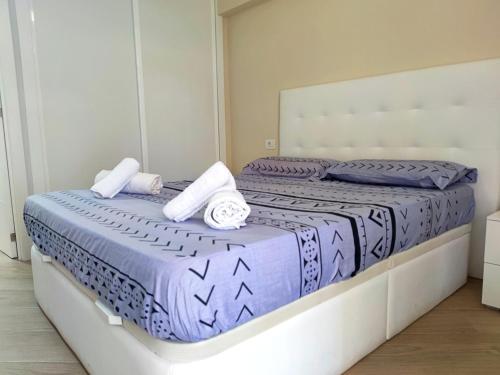 a bedroom with two beds with blue and white sheets at Playa de las Americas 600mt from the beach internet free in Playa de las Americas