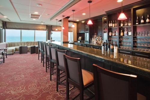 a bar with a row of chairs in a room at Holiday Inn & Suites Virginia Beach - North Beach by IHG in Virginia Beach