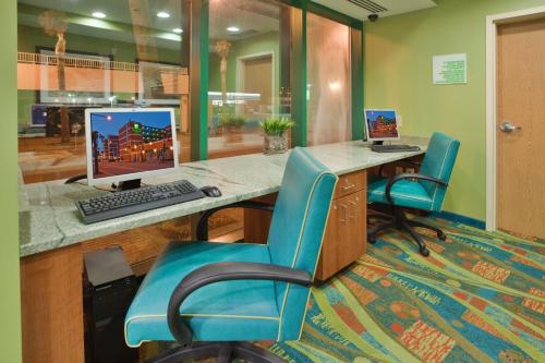 an office with a desk with a computer and two chairs at Holiday Inn & Suites Virginia Beach - North Beach by IHG in Virginia Beach