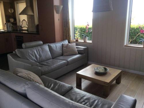a living room with a couch and a coffee table at Dijkhuisje Zeeland in Waterlandkerkje