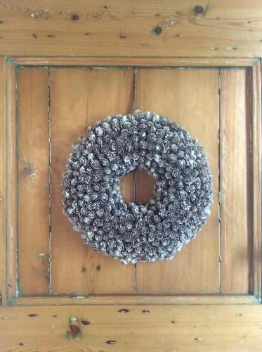a wreath on a wooden wall with a wooden practition at Dijkhuisje Zeeland in Waterlandkerkje