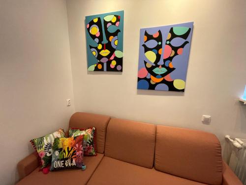 a living room with a couch and three paintings at Willa 1936 , Parking in Toruń