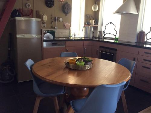 a kitchen with a wooden table with a bowl of fruit on it at Dijkhuisje Zeeland in Waterlandkerkje