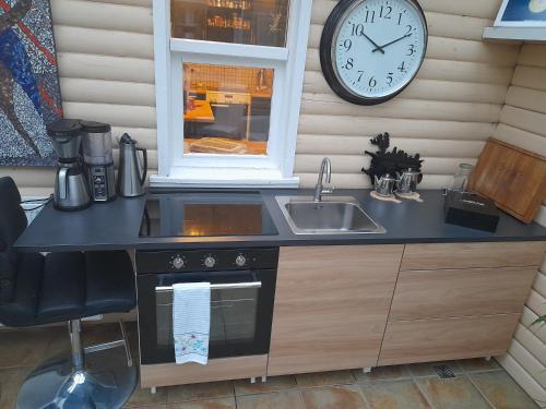a kitchen with a sink and a clock on the wall at Country Dream - Langholt 2 in Selfoss