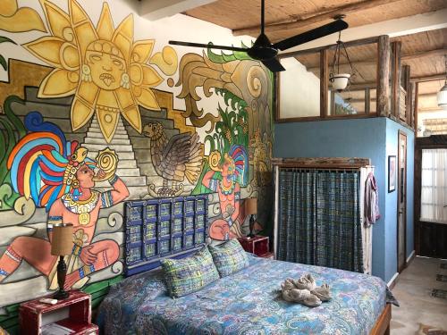 a bedroom with a mural on the wall at Pueblo Maya by Majikal B&B in Mérida