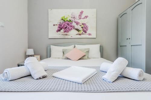 1 cama blanca con almohadas blancas y una pintura en Calma Luxury Apartments #4 Sozopoli in Halkidiki, en Sozopoli
