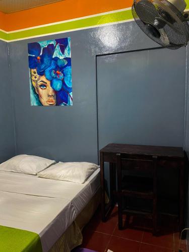 a bedroom with a bed and a painting on the wall at Hostal tortuga viajera in Moyogalpa