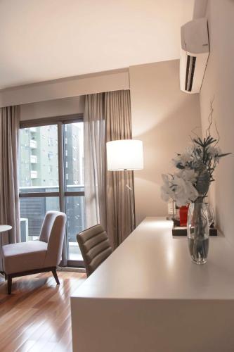 a living room with a table and a chair at NH Collection Curitiba in Curitiba