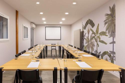 a large conference room with long tables and chairs at Best Western Plus d'Europe et d'Angleterre in Mâcon